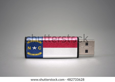 usb flash drive with the north carolina state flag on gray background. concept
