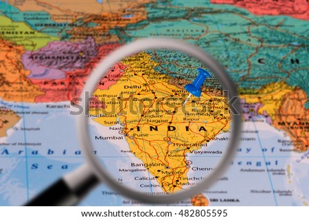 Magnifying glass with the Map of India with a blue pushpin stuck