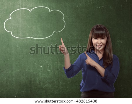 Asian business woman pointing bubble speech over blackboard background
