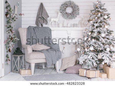 Stylish Christmas interior decorated in gray colors. Comfort home. Armchair with fabric upholstery Royalty-Free Stock Photo #482823328