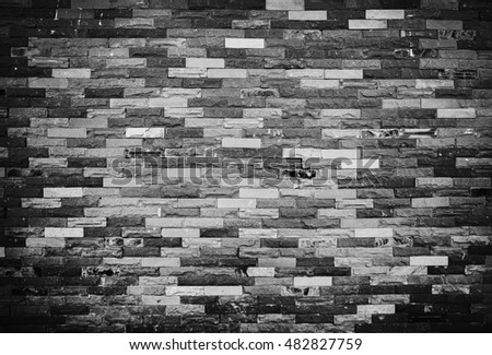 Old grunge brick wall background. Texture of stained old dark brick wall background, horizontal architecture for your text. Black and white picture style.