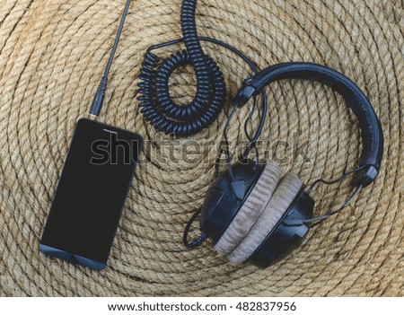 smartphone and headphone music  on a jute rope background