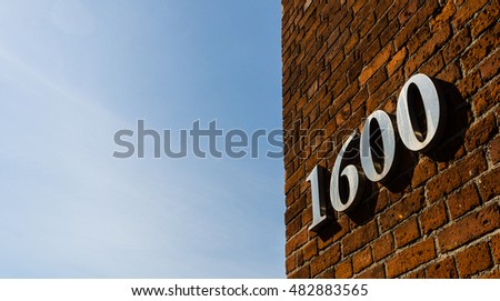 Building with address sign saying 1600 against blue sky on a sunny day