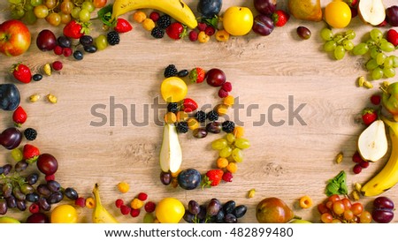 Fruits made letter B. The composition of bright ripe fruits. Letter on wood table                              