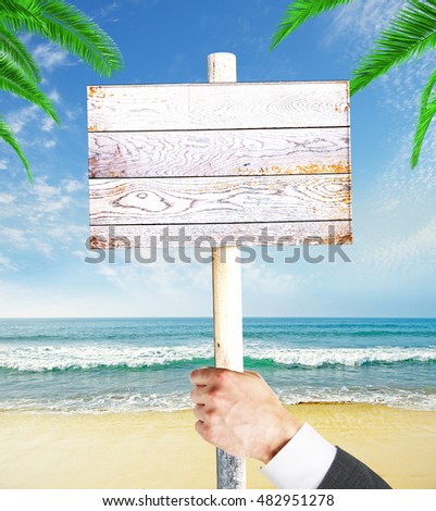Businessman hand holding empty wooden signboard on seashore background. Mock up, 3D Rendering