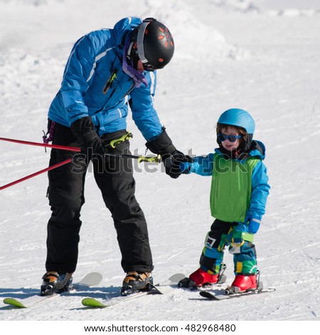 Ski trainer learning little boy to ski