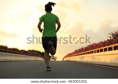 young asian woman runner running on road
