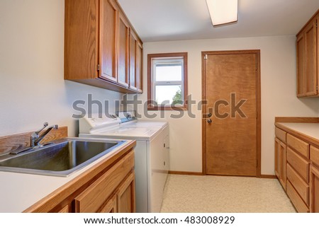Laundry room with wooden cabinets and stainless sink. Northwest, USA