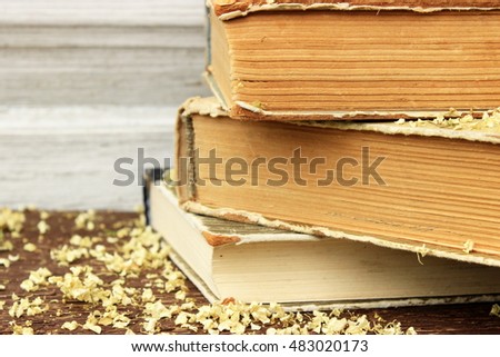 Romantic composition with stack of vintage books with very old paper and covers on wooden background. Copy space