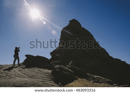 Silhouette of photographer taking pictures of Sphinx - Bucegi mountains, Romania.
