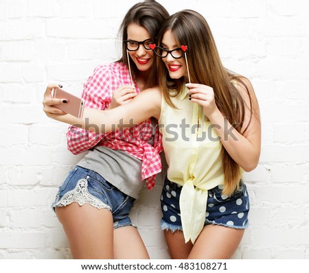 two young women  with party glasses taking selfie