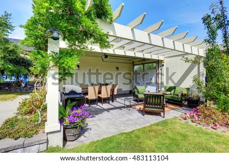 Covered patio area with outside chairs in the backyard garden. House exterior. Northwest, USA