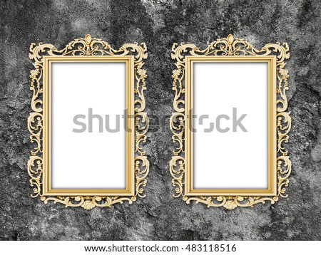 Close-up of two golden Baroque picture frames on dark gray concrete wall background