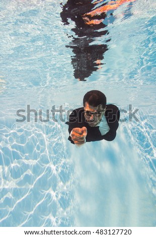 businessman swimming underwater in the pool