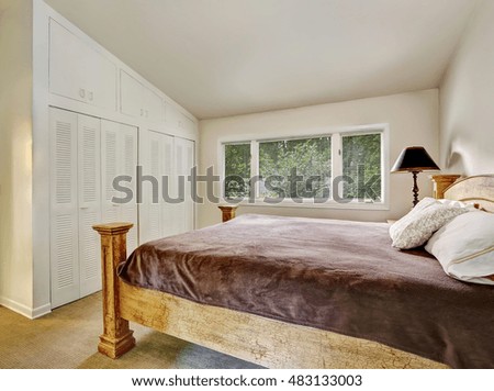Bedroom interior with wardrobe, wooden bed with brown bedding. Northwest, USA