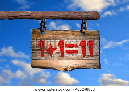 1+1=11 motivational phrase sign on old wood with blurred background