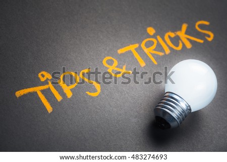 Tips and Tricks, handwriting on chalkboard with glowing light bulb