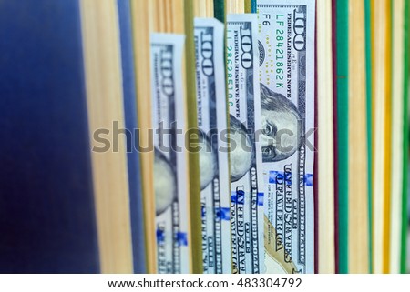 the denomination hundred dollars lie between pages of the book, saving hidden.