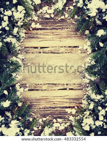 Christmas fir tree with snow on a wooden background