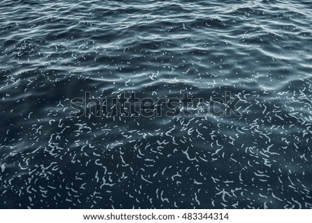 Sea surface aerial view. Background shot of clear sea water surface. Blue sea water in calm. Sea texture. Background blue waves of the sea with sea foam.