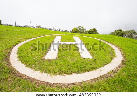Helicopter landing port on green grass with sky in nature