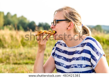 Eating pizza, woman relaxing in nature