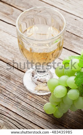 White grape and glass of wine on wooden table