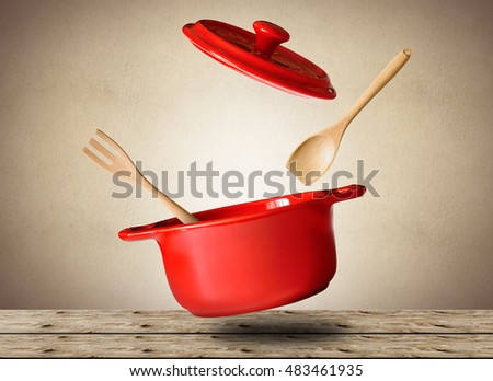 Big red pot for soup with spoon and fork Royalty-Free Stock Photo #483461935