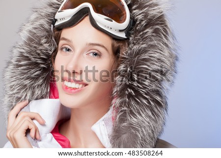 Woman skier girl wearing warm clothing ski goggles portrait. Winter sport activity. Beautiful sports women on blue studio shot.  winter sports.  