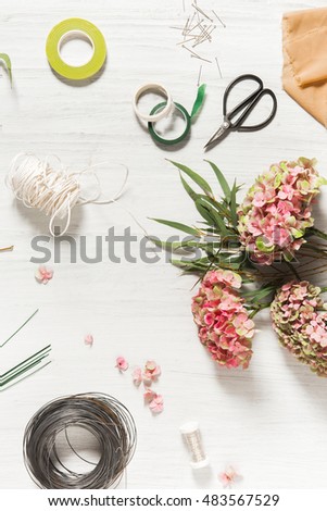 The florist desktop with working tools on white wooden background