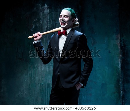 Bloody Halloween theme: The crazy joker face on black background with baseball bat
