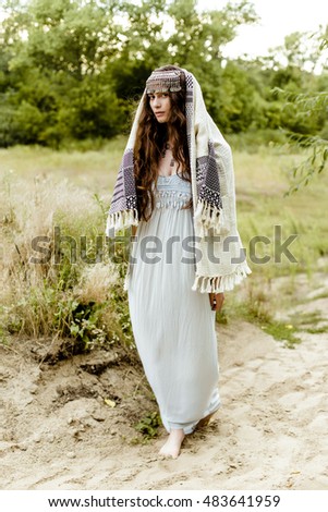 Young girl in traditional folk Crimean Tatar clothes walking in fields