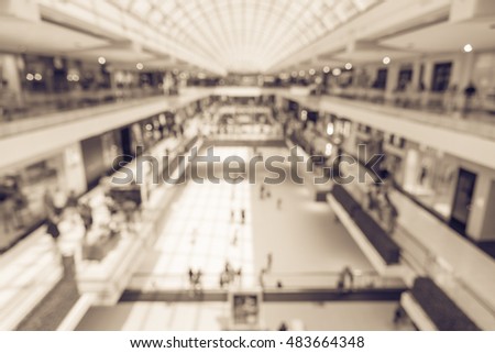 Blurred image interior of main hall shopping mall showing the ice rink and large skylight, natural light from glass roof. Glazed barrel vault spanning central axis, fashion boutique corridor. Vintage.