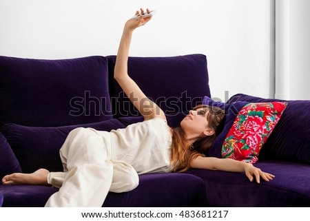 Woman taking picture of herself on sofa