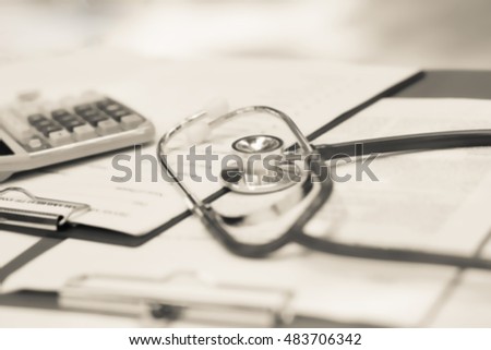 Blurred background of Health care costs concept picture : Stethoscope and calculator on a medical chart ,symbol for health care costs or medical insurance in tone.
