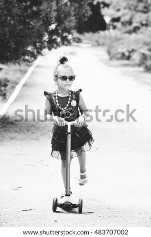 little fashion girl on the scooter in summer time