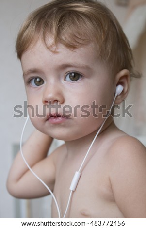 beautiful happy baby with headphones listening to music