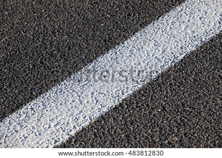  photographed close-up of the new road for the movement of vehicles, a dark cover the carriageway road markings - white stripes
