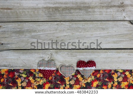 Blank rustic wooden sign with fall decor border of colorful leaves and country hearts