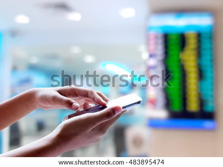Man use mobile phone, blur image of bank as background.