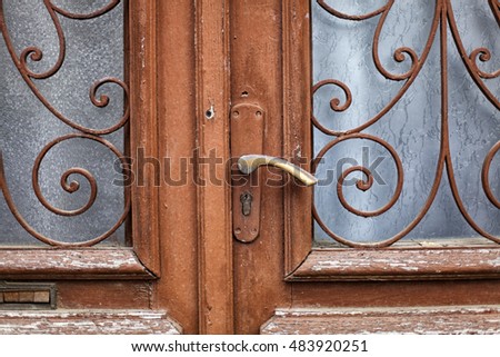 Wrought Iron Double Door Made of Wood with Pattern Over Windows and Door Handle