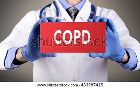 Doctor's hands in blue gloves shows the word COPD (chronic obstructive pulmonary disease). Medical concept.