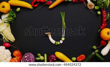 Vegetables made letter J. Tomatoes, cabbage, peppers and other vegetables on a black background. Cabbage, radishes and mushrooms on a table of black wood.                               