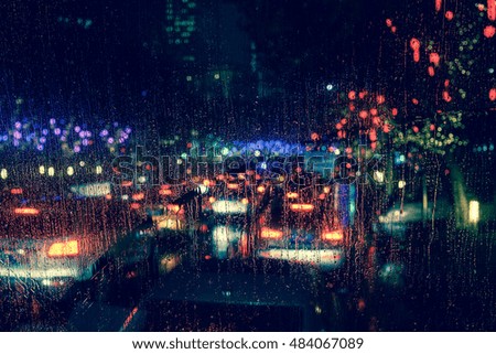 Rain drops on window with road light bokeh, City life in night in rainy season abstract background,water drop on the glass, night storm raining car driving concept.