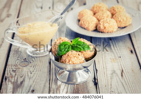 Cottage cheese balls in a peanut sprinkled with apple-basil sauce. Dessert masquerades as ice-cream. Vignetting.