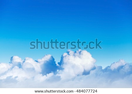 Cloudscape with white cumulus clouds in bright blue sky, natural photo background