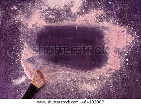 A makeup brush on a purple background, with traces of powder and blush on it forming a frame. A horizontal template for a makeup school business card or flyer design, with plenty of copyspace