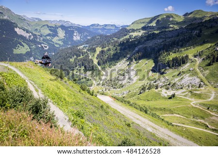 Man going for an extreme Zip-line flight over the alpine landscape in summer, Alps mountain massif, Cantons Vaud and Valais, Swiss Alps, Switzerland