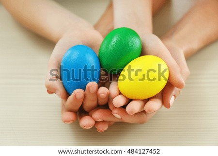 Mother and daughter holding Easter eggs