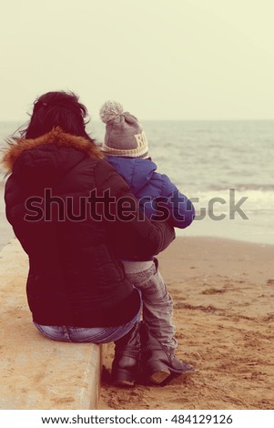Mother and son watching the sea in winter